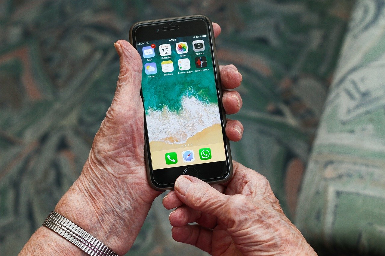 An elderly person holding an iPhone