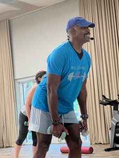 Man leading a work-out class, holding dumbells
