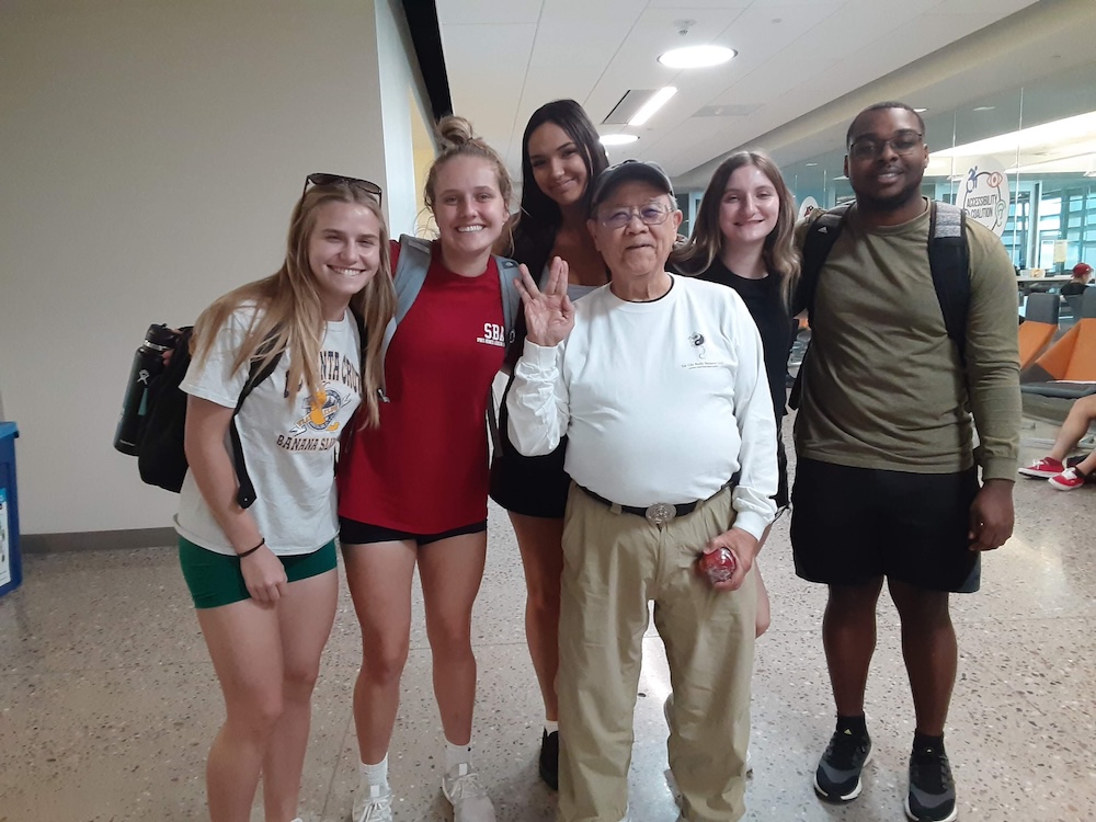 senior male professor with group of college students